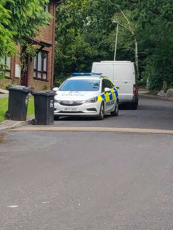 Police car parks near the trashの写真素材