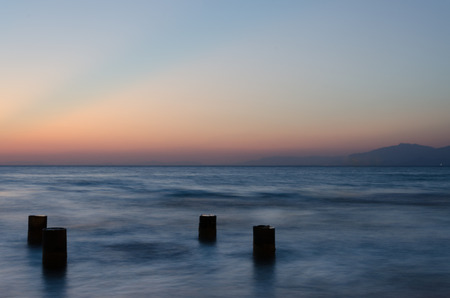 Columns from pier in sea bay after sunsetの写真素材