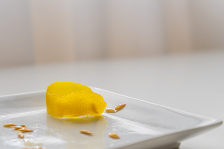 Empty plate with seeds and peel (or husk) of yellow melon. White plate. Neutral background.の写真素材