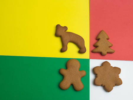 Happy New Year and Merry Christmas gingerbread on a red yellow green white background. Christmas baking. Making gingerbread christmas cookies. Christmas concept.の写真素材