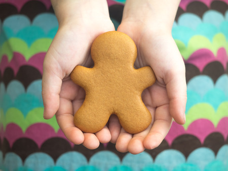 Happy New Year and Merry Christmas gingerbread in girl's hands. Christmas baking. Making gingerbread christmas cookies. Christmas concept.の写真素材