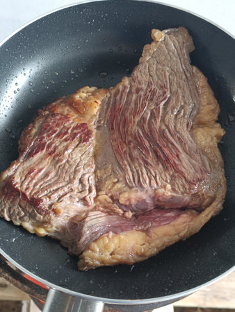 Beef steak in a frying pan, closeup of photo.の写真素材