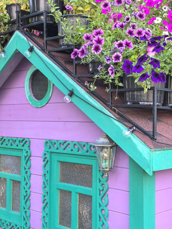 Pink and turquoise house with intricate design and purple flowers. High quality photo
