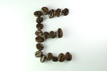 Coffee Beans, the alphabet E is formed with coffee beans in white backgroundの写真素材