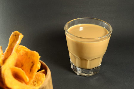 A glass of coffee milk and tortilla chipsの写真素材