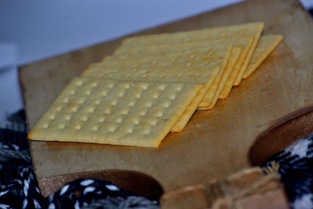 Cheese crackers on a wooden board with a slightly blurry white background