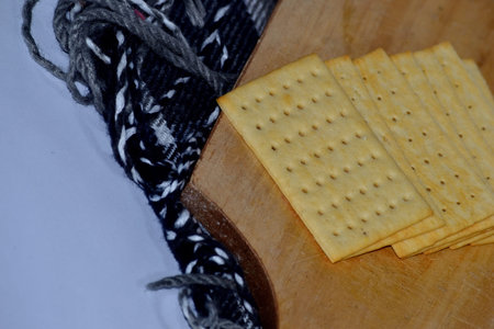 Cheese crackers on a wooden board with a slightly blurry white background