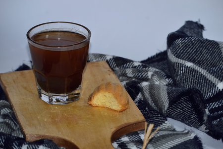 A cup of black coffee and dry sponge. White background and cloth