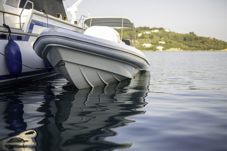 Small motorboat at the dock with beautiful reflections in the waterの写真素材