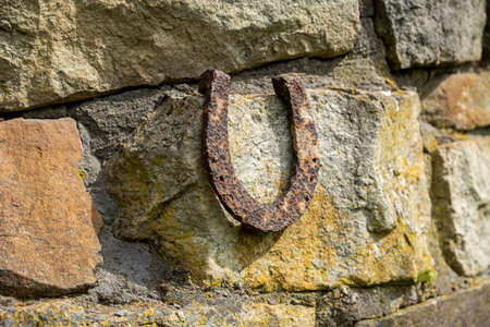 An old rusty horseshoe propped on a big stone. Symbol of happiness and luck.の写真素材
