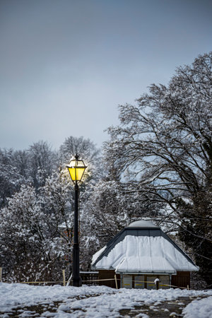 View with beautiful glowing lantern in a peaceful snow evening in the mountains in Austria.の写真素材