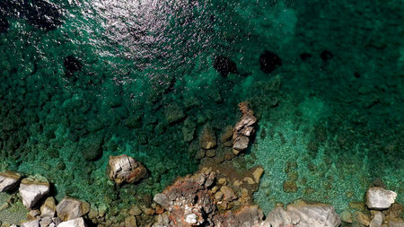 Aerial drone views over a rocky coastline, crystal clear Aegean sea waters, touristic beaches and...