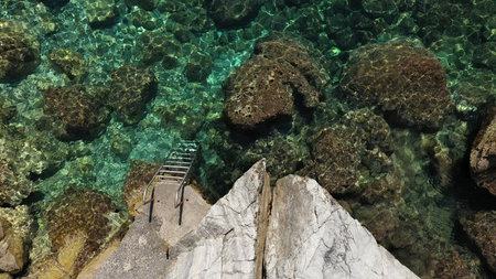 Aerial drone views over a rocky coastline, crystal clear Aegean sea waters, touristic beaches and...