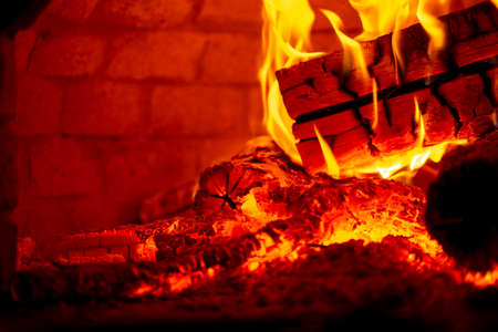 Burning log of wood in a fireplace close-up.の写真素材