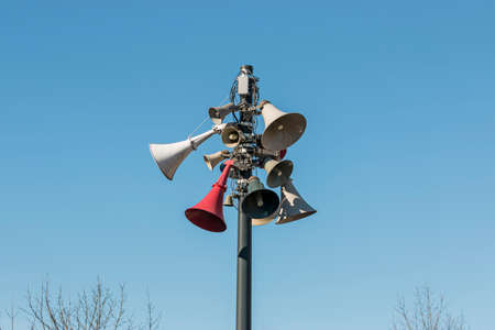 Megaphones on a pole with a blue sky background, Old style public address system, speakers on high tower, Warning system.の写真素材