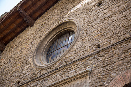 Large vintage round window with bars. Decorative element of an old renaissance building.の写真素材