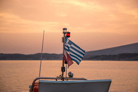 View of a Greek flag with the sunset in the background.の写真素材