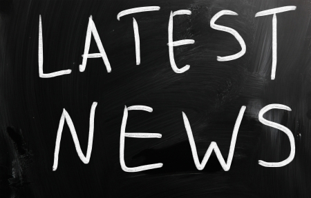 "Latest news" handwritten with white chalk on a blackboardの写真素材