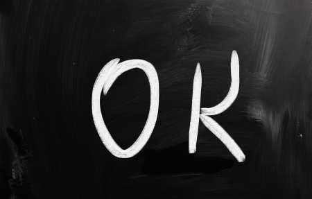 "OK" handwritten with white chalk on a blackboardの写真素材