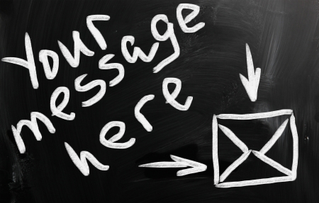 "Your message here" handwritten with white chalk on a blackboardの写真素材