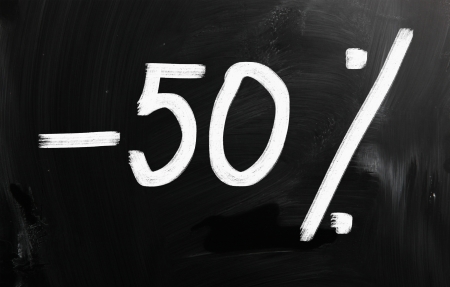 "50% off" handwritten with white chalk on a blackboardの写真素材
