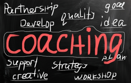 "Coaching" handwritten with white chalk on a blackboardの写真素材