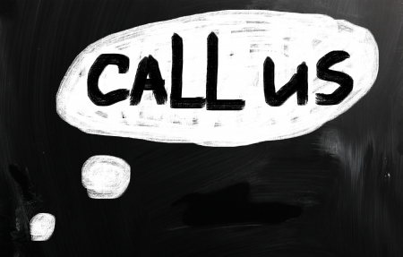 "Call us" handwritten with white chalk on a blackboardの写真素材
