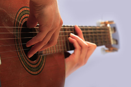 man playing guitar in a gray background