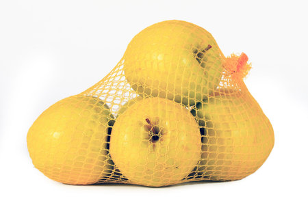 yellow apples in network on white backgroundの写真素材