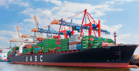 Hamburg, Germany - July 12, 2011 : Heavily laden container cargo ship docked on south shore of Elbe...
