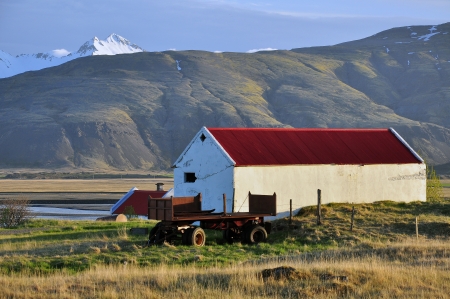 Farm with a red roof in Iceland on sunsetの写真素材