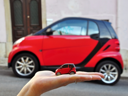 LISBON, PORTUGAL - DECEMBER 9  Red Smart Car and the mini model in the same colour in the street of Lisbon on July 5, 2008  Smart is a city car with company headquarters in Germany のeditorial素材