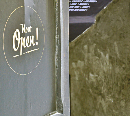 "Now Open" sign on the black doorの写真素材