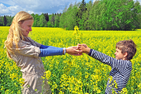 Boy giving bouquet of wildflowers to motherの写真素材