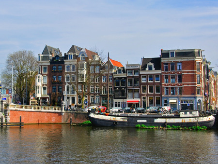 AMSTERDAM, NETHERLANDS - MARCH 27: Houses on the street by the river in Amsterdam on March 27, 2012. Amsterdam is the capital and most populous city of the Netherlands.のeditorial素材