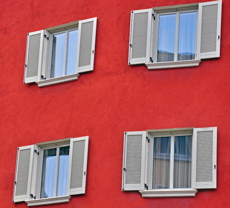 Open windows on red wallの写真素材