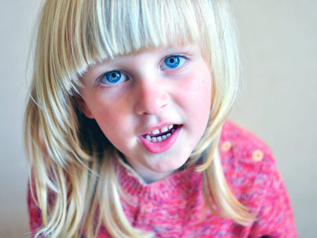 Smiling boy with a long blonde hair