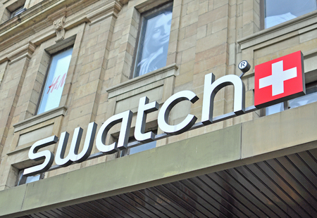 GENEVA, SWITZERLAND - SEPTEMBER 3: Logo of Swatch company in the store in Geneva on September 3, 2015. Swatch is the world famous watch company based in Switzerland.のeditorial素材