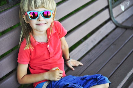 Portrait of a smiling kid on the benchの写真素材