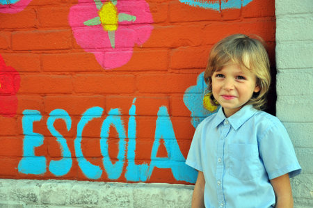 Smiling boy at the wall in school yard