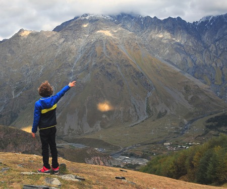 Back view of a boy standing in mountainsの写真素材