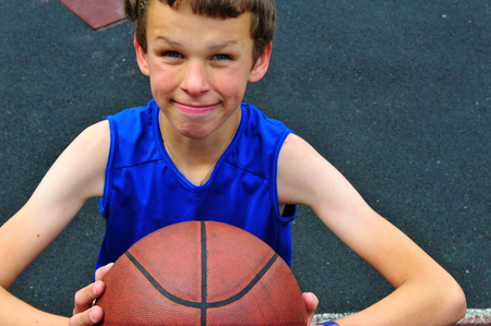 Little basketball player preparing for throwing ball on basketball courtの写真素材