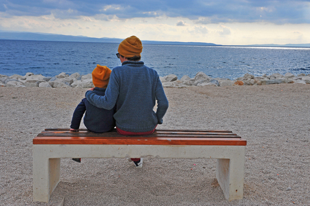 Dad with a son at the sea on autumn dayの写真素材