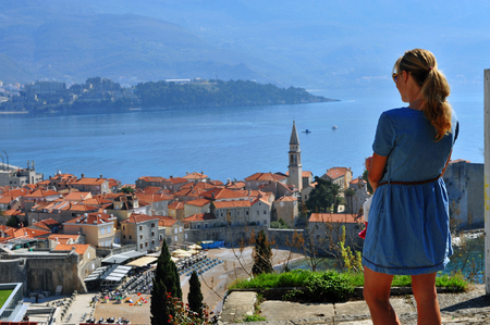 Young woman looking at Budva old town, Montenegroの写真素材