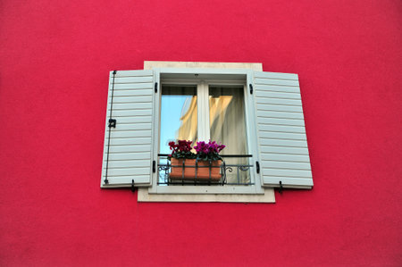 Beautiful wooden window in the deep red wallの写真素材