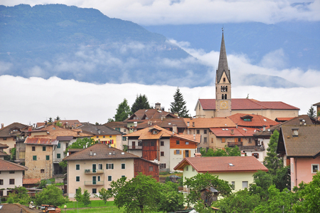 Beautiful alpine village with clouds on the groundの写真素材