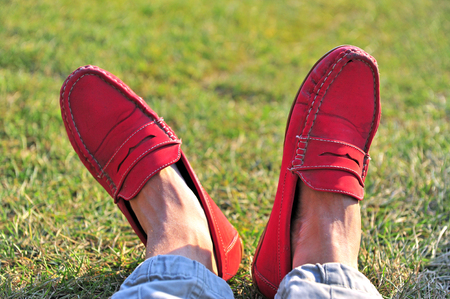 Mens legs in red moccasins on the grassのeditorial素材