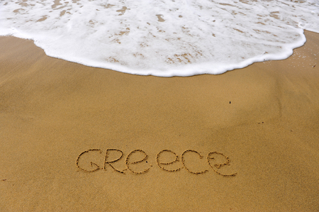 Greece beach sign with waves and sand on backgroundの写真素材