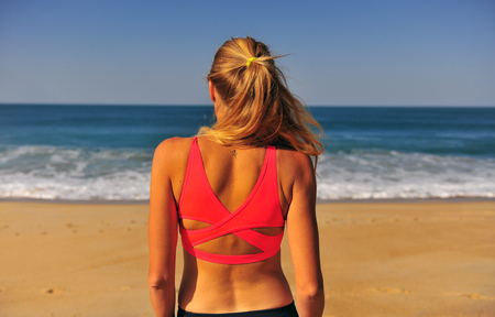 Girl looking at ocean on the clear sunny dayの写真素材