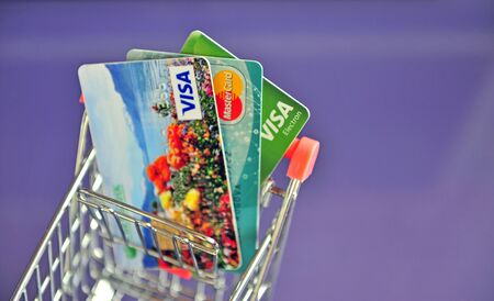 Yaroslavl, Russia - August 20, 2019: Mini shopping trolley with credit cards on the table.のeditorial素材